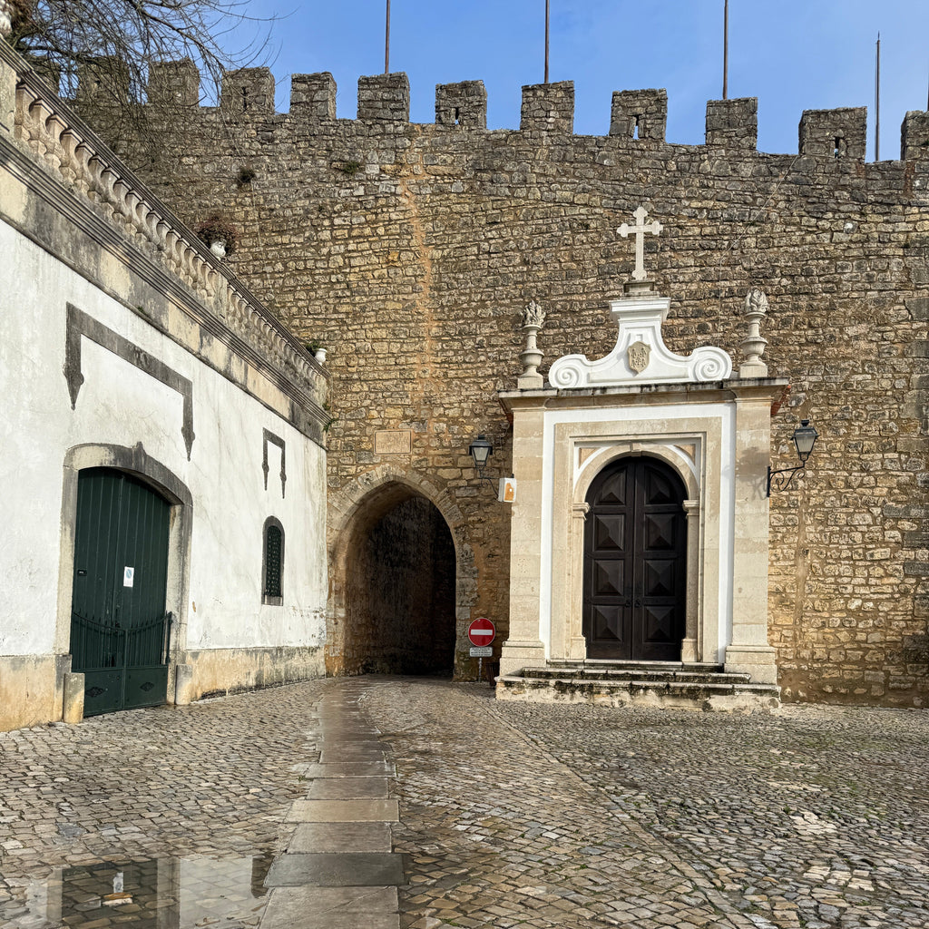 Stone building with arched entrance and cobbled street